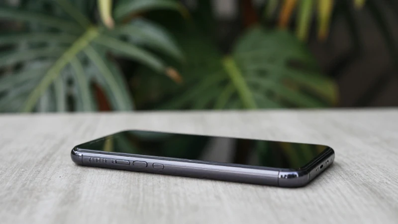 Smartphone sobre mesa con follaje tropical