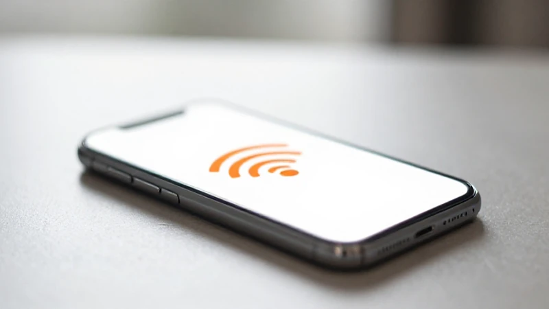 Celular sobre mesa, señal naranja borrosa