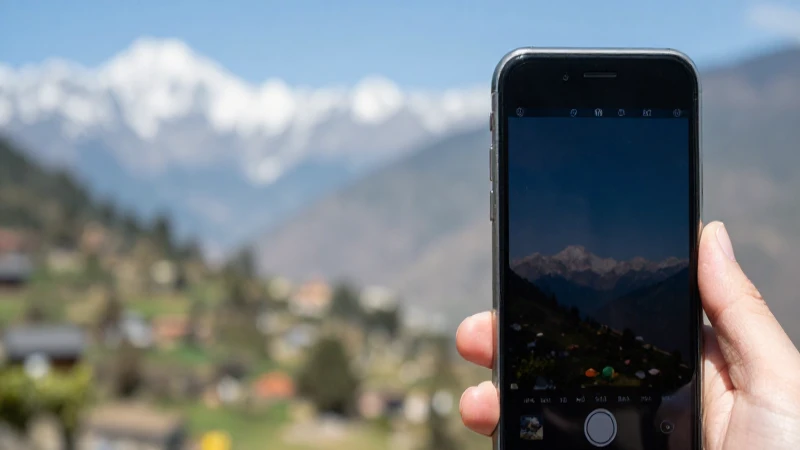 Primer plano iPhone, paisaje nepalí desenfocado