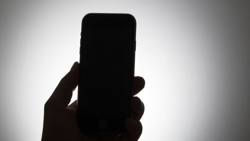 Teléfono móvil iluminado desde atrás en estudio