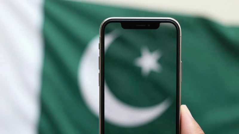 Pantalla del móvil enfocada, fondo borroso pakistaní