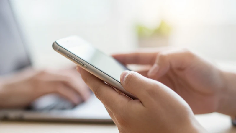 APN US Straight Talk APN Settings for iPhone Explained 4 Manos escriben sobre un iPhone desenfocado