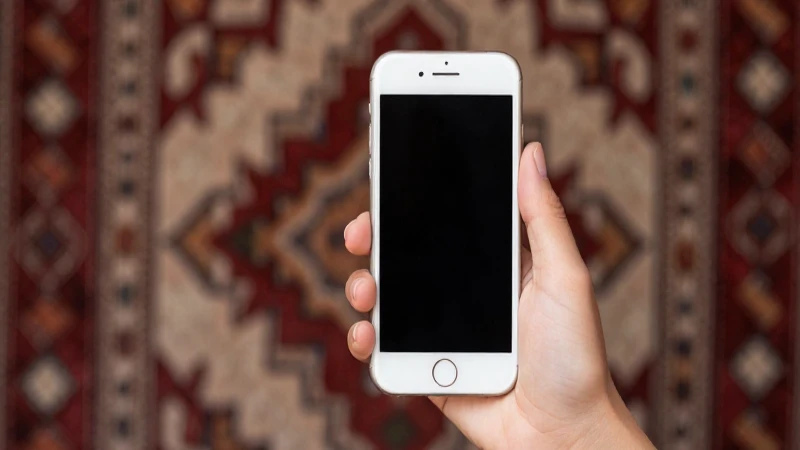 Smartphone en mano, textil uzbeko, luz suave